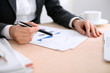© rogerphoto - Business woman sitting at the table and examines the financial results