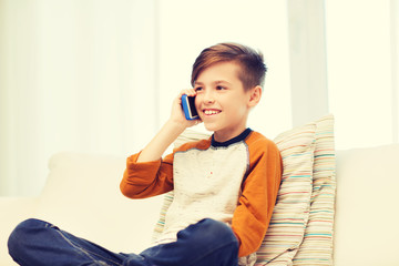 Wall Mural - happy boy calling on smartphone at home