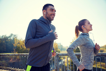 Canvas Print - happy couple with earphones running outdoors