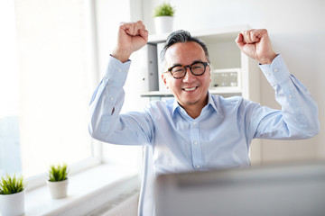 Canvas Print - happy businessman with laptop at office