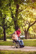 © luckybusiness - Happy senior man in wheelchair and daughter in the park.