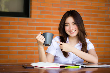 Portrait of thai adult student university uniform beautiful drinking coffee