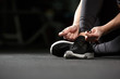 © Drobot Dean - Cropped image of young fitness lady tie laces in gym.