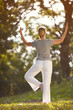 © luckybusiness - Female practicing yoga in park