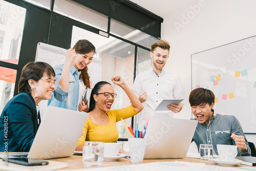 Fotografía Multiethnic diverse group of coworkers celebrate together with laptop and tablet