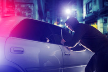 Car Thief In Action At Night. Car Security Theme.