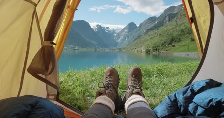 camping woman lying in tent close up of girl feet wearing hiking boots relaxing on vacation pov