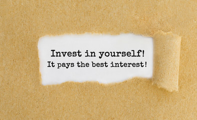 Aufkleber - Invest in yourself, it pays the best interest appearing behind ripped brown paper.