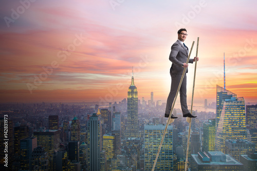 Fotografia, Obraz Businessman walking on stilts - standing out from the crowd