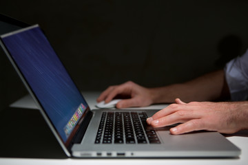 Hand typing on a keyboard of laptop with operating system screen on background