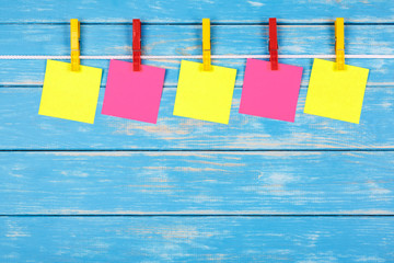 Yellow and red clothespins on a rope with five cards