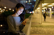 © leungchopan - Woman using mobile phone at night