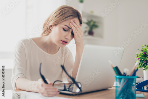 Cuadros en Lienzo Overworked businesswoman suffering from headache and thinking how to end work
