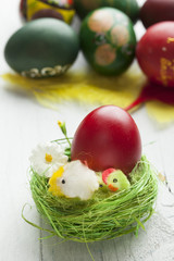 Red easter eggs on old wood table with feather and chicken