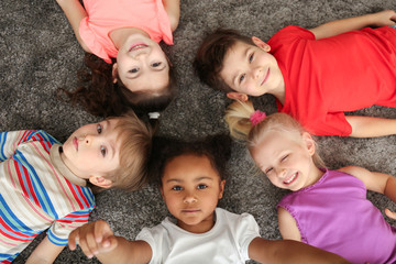 Canvas Print - Cute little children lying on carpet at home