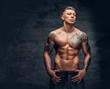 © Fxquadro - A man with tattoo on his chest over grey background.