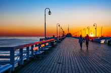 Sunrise At The Wooden Pier (molo) In Sopot, Poland And An Unrecognizable Walking Couple
