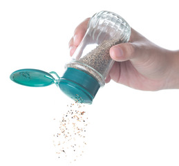 Sticker - Hand holding bottle of black Pepper shaker on white background.