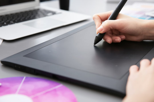 Young designer drawing sketches on graphic tablet, closeup