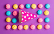 photo of tasty colorful marshmallows and Birthday hat on the wonderful purple background