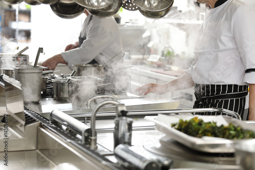 Chef in hotel or restaurant kitchen cooking Tableau sur Toile