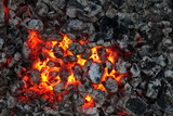 Fototapeta  - Charred wood and bright flames on dark background