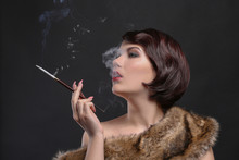 Young Woman Smoking With Cigarette Holder On Dark Background