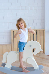 cute little girl sitting on toy horse. day of protection of children