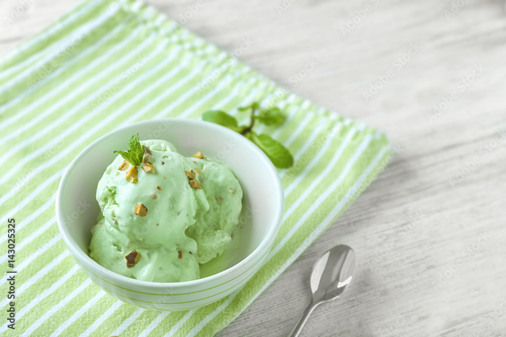 Bowl with delicious pistachio ice cream on napkin