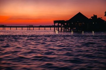 Wall Mural - silhouette of water bungalows at twilight, beautiful landscape