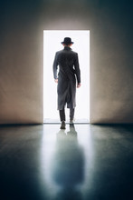 Man Silhouette Walking Away In The Light Of Opening Door In Dark Room