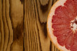 Juicy. Cropped closeup shot of a grapefruit slice lying on a wooden table copyspace on the side.
