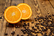 Summer spirit. Shot of a halved orange on a wooden table full of coffee beans spilled around.