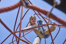 Active Young Child Girl Climbing The Spider Web Playground Activity. Children Summer Activities.