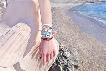 model advertises bohemian greek jewelry on the beach