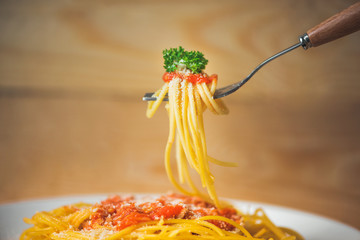 Wall Mural - Close-up of asta spaghetti with tomato sauce, olives and garnish. Italian food.