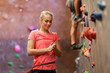 young woman exercising at indoor climbing gym wall