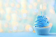Tasty Cupcake With Candles On Lights Background