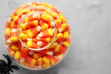 Sticker - Vase with tasty Halloween candies on light background