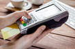 © 279photo - Payment by card in cafe with terminal and keyboard on wooden background