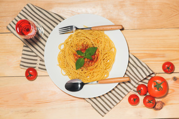 Wall Mural - Top view of spaghetti with tomato sauce and meat on wooden table.