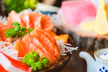 Close-up salmon raw sashimi on brown Japanese traditional dish on black table.