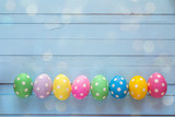Fototapeta  - Colored Easter eggs on blue wooden background.