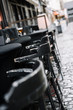 © alexkaishauri - European city street with black chairs in a row.