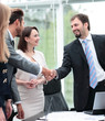 © ASDF - Two business people shaking hands and looking at each other with