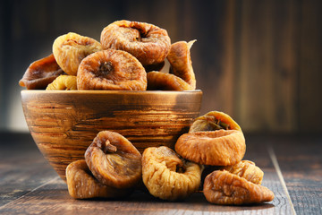 Canvas Print - Composition with bowl of dried figs on wooden table