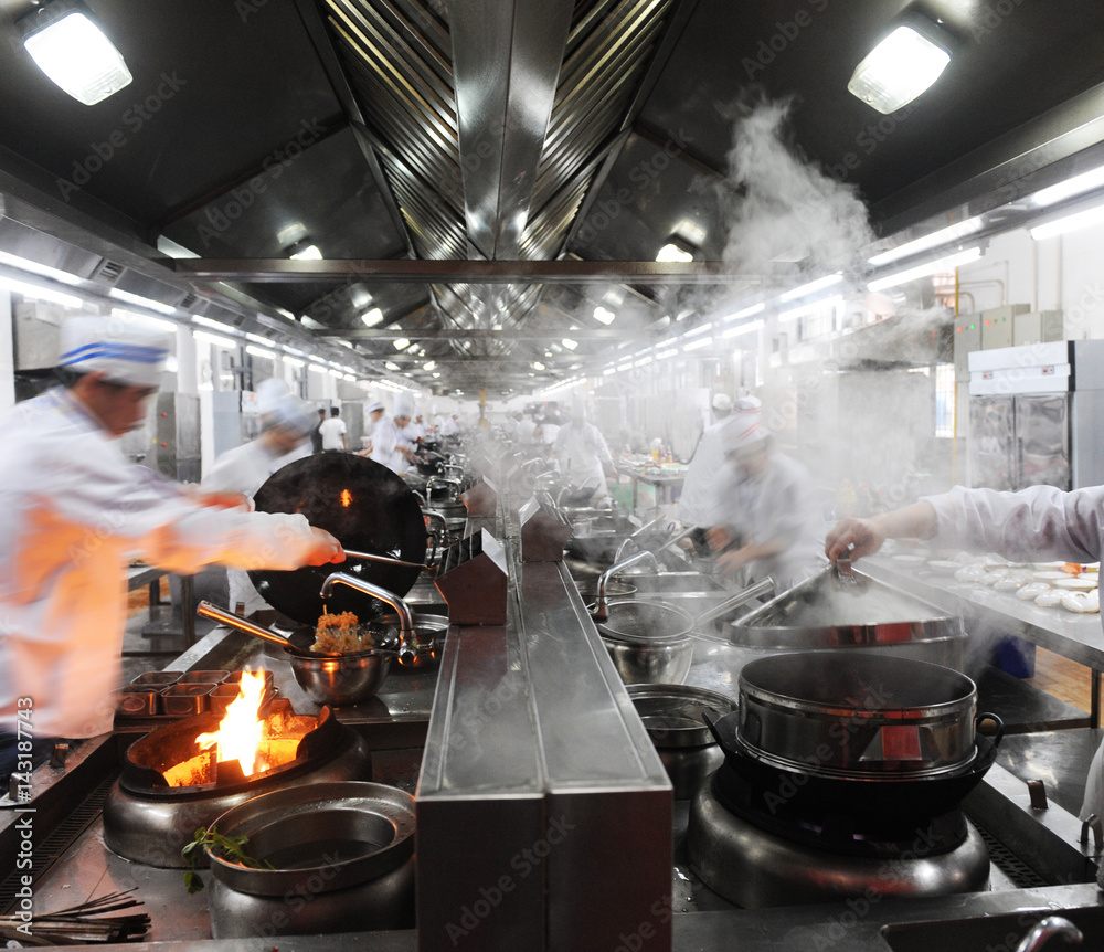 Motion chefs in a Chinese restaurant kitchen. - obrazy, fototapety, plakaty 