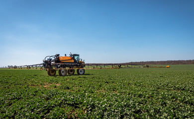 Aufkleber - Farm machinery spraying insecticide to the green field.