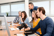 © W PRODUCTION - group of five young people student with their teacher in photography school learning photo editing with desktop computer, camera and photo equipment