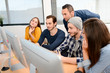 © W PRODUCTION - group of five young people student with teacher in computer school classroom learning programming with desktop computer in a row